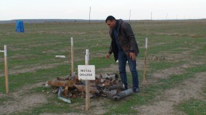„International Eurasia Press Fund“ atstovas Ramilas Azizovas demonstruoja, kokias minų ir sviedinių skeveldras jie aptinka po apšaudymų.